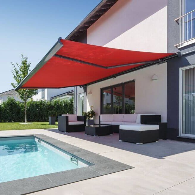 Rote Markise über einer Terrasse mit Sitzgelegenheiten und einem Pool im Vordergrund.