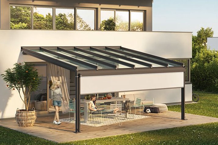 Moderne Überdachung an einem Haus mit Glas-Schiebewänden und Terrassensituation im Garten.