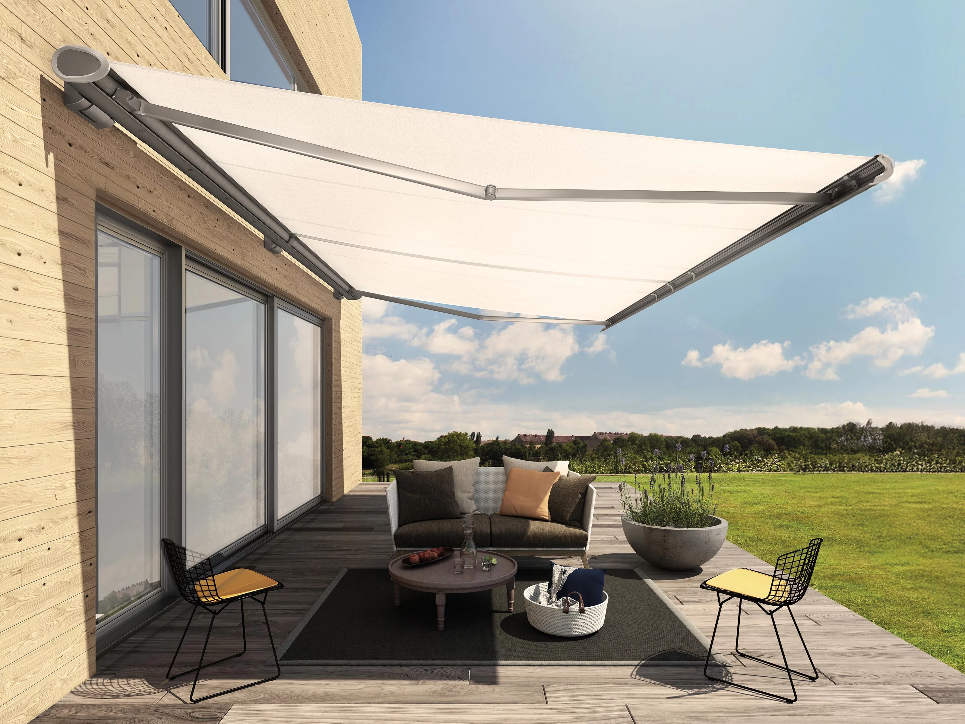 White awning extends over a terrace with seating and a round table, set against a sunny outdoor landscape.