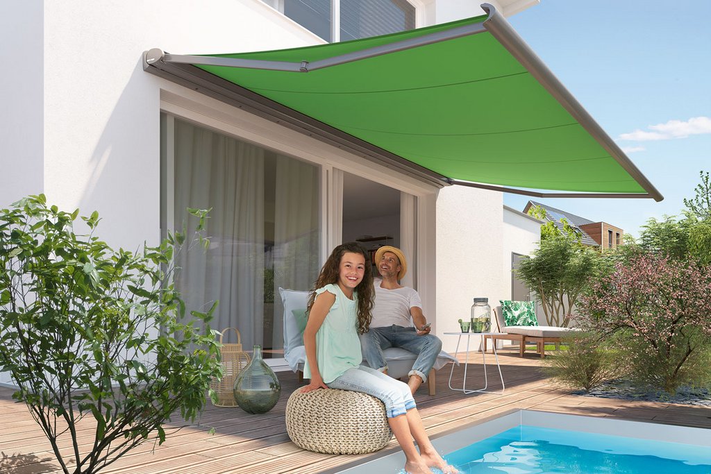 Image d'un espace extérieur avec une piscine, une terrasse, des plantes et une marquise verte.