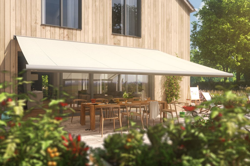 Un auvent beige s'étend au-dessus d'une terrasse avec des chaises et des tables en bois, entouré de verdure.