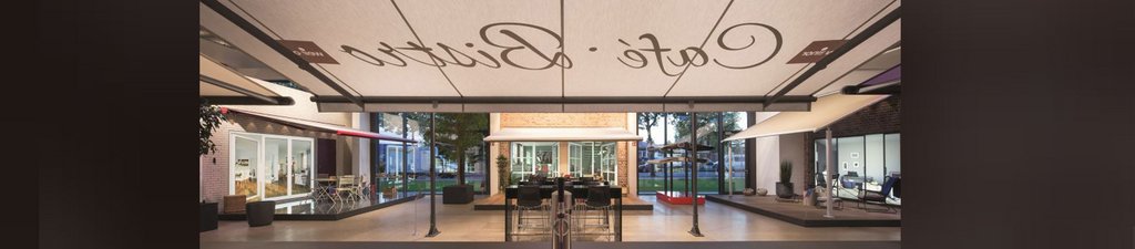 Markise über einem Café mit eleganter Schrift und Sicht auf einen Außenbereich.