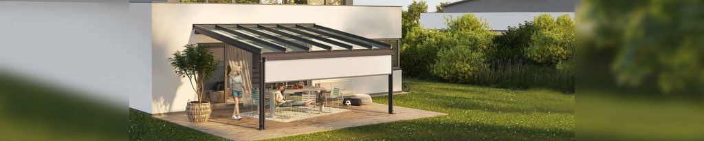 Moderne overkapping met glazen dak, zwarte afwerking en groene tuin op de achtergrond.