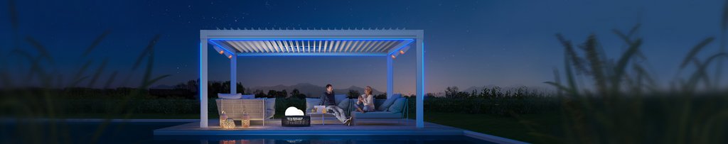 Eine moderne Überdachung mit LED-Beleuchtung, Personen und gemütlicher Terrassensituation bei Nacht.