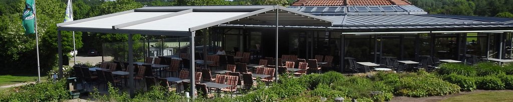 Eine Terrasse mit Markisen und Überdachung, umgeben von Pflanzen und einem Gebäude im Hintergrund. Eine Terrasse mit Markisen und Überdachung, umgeben von Pflanzen und einem Gebäude im Hintergrund.